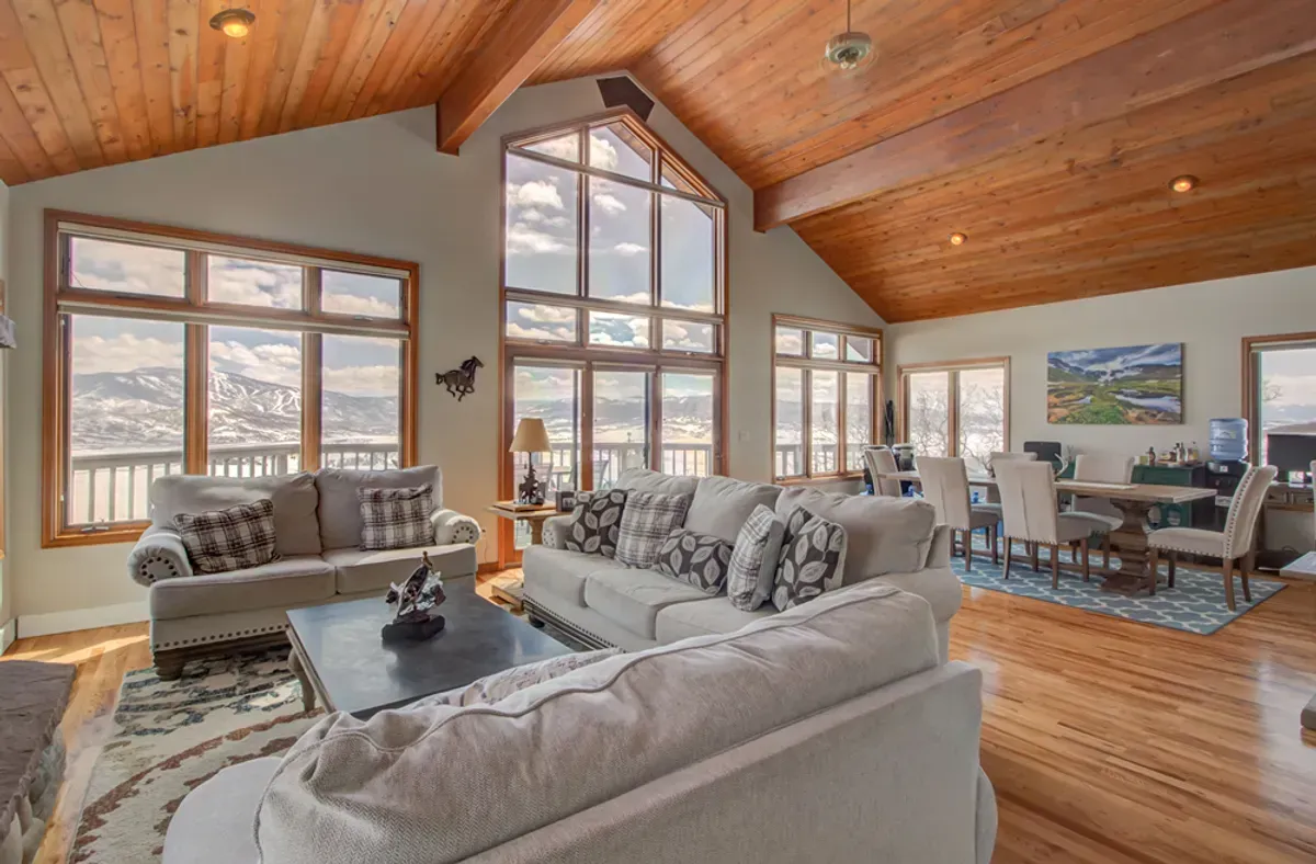 A living room filled with furniture and a vaulted ceiling.