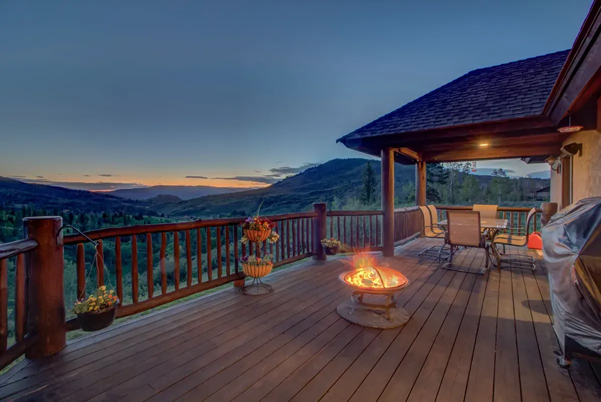 There is a fire pit on the deck of a house.