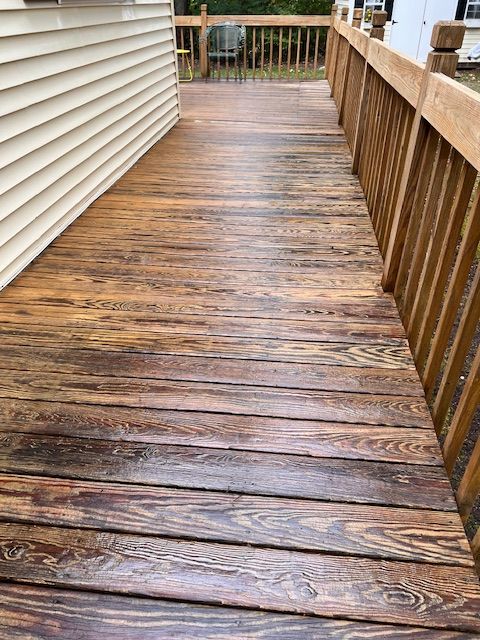 A wooden deck with a white house in the background.