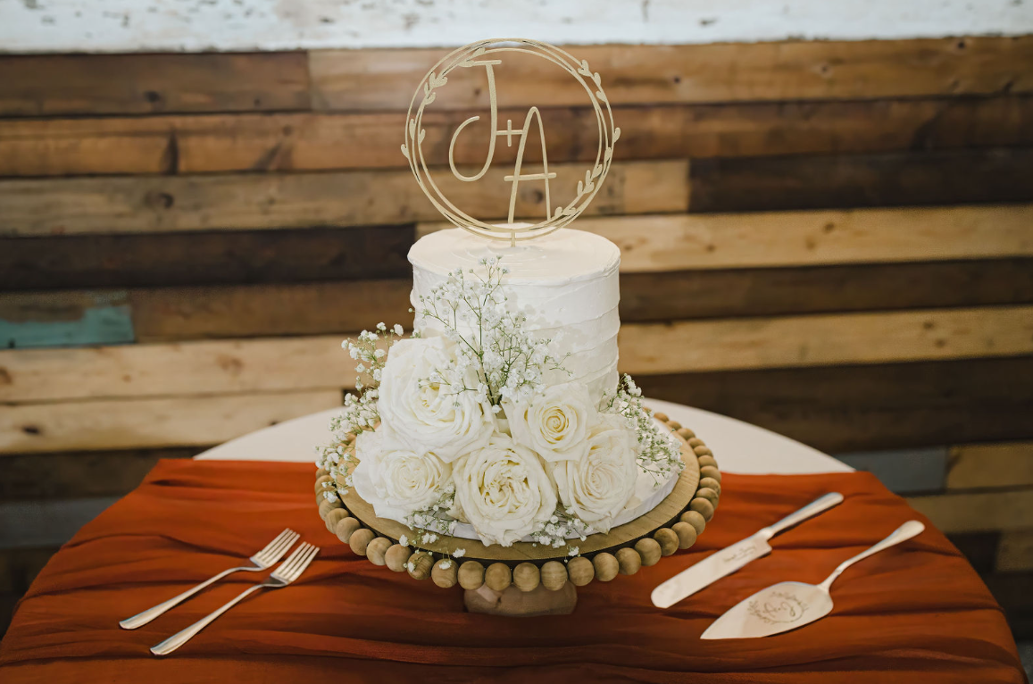 A white wedding cake with white roses and baby's breath, a