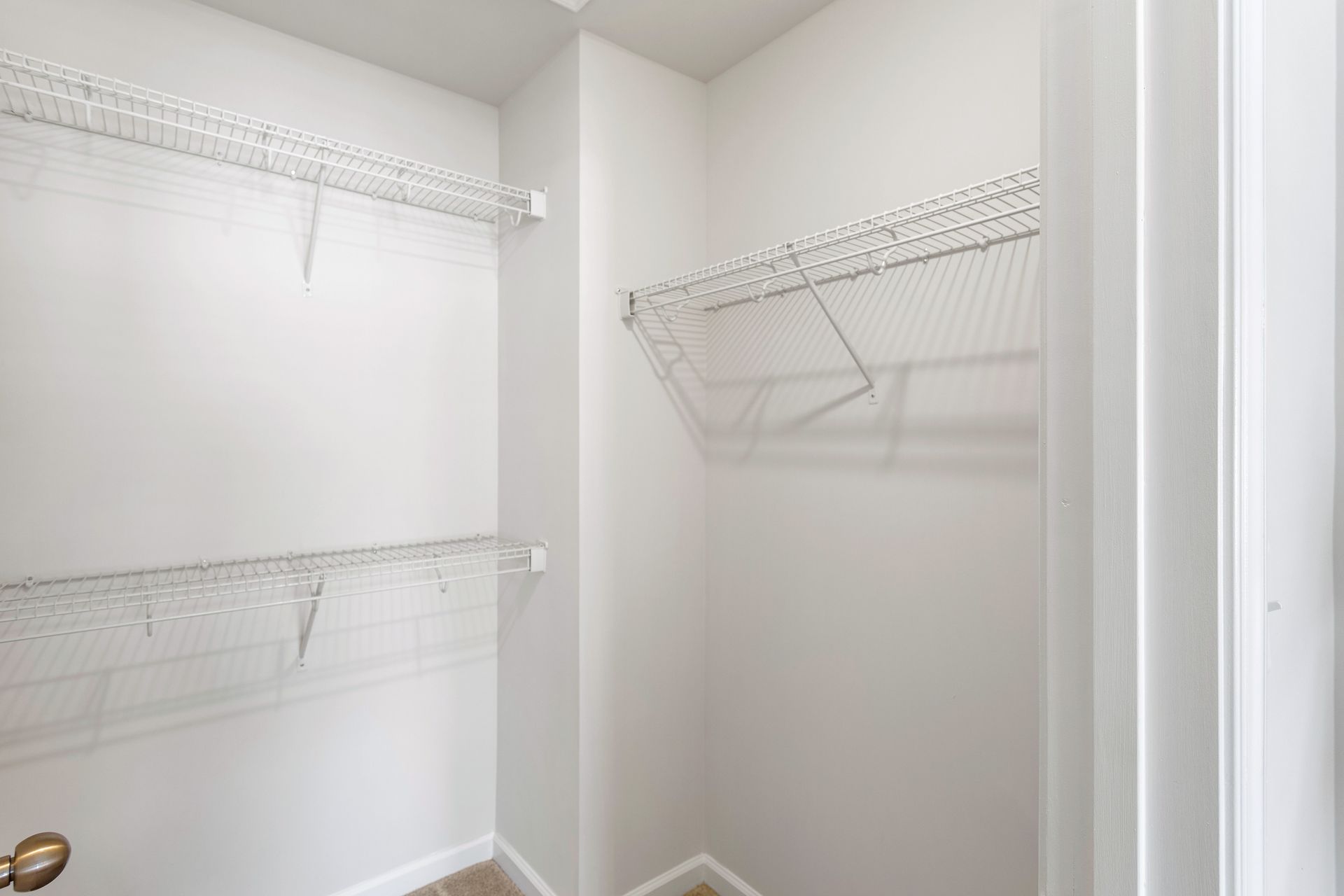 A walk in closet with lots of shelves and a door.