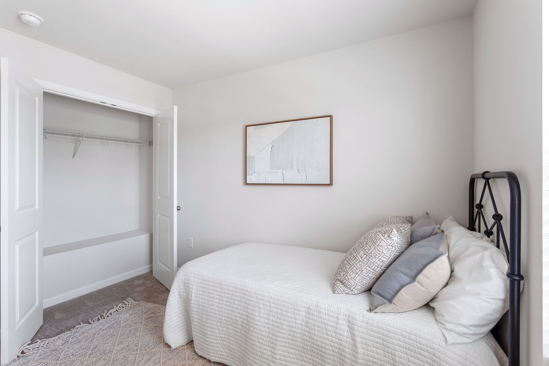 A bedroom with a single bed and a closet.