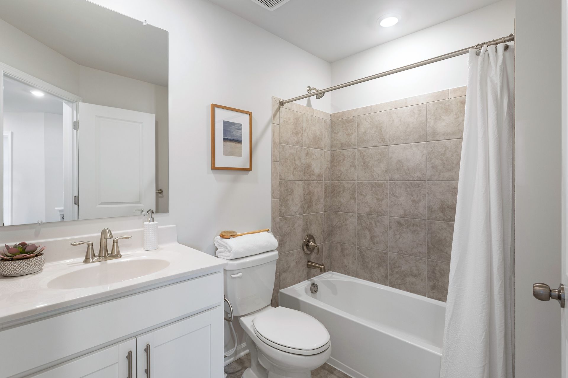 A bathroom with a toilet , sink , and bathtub.