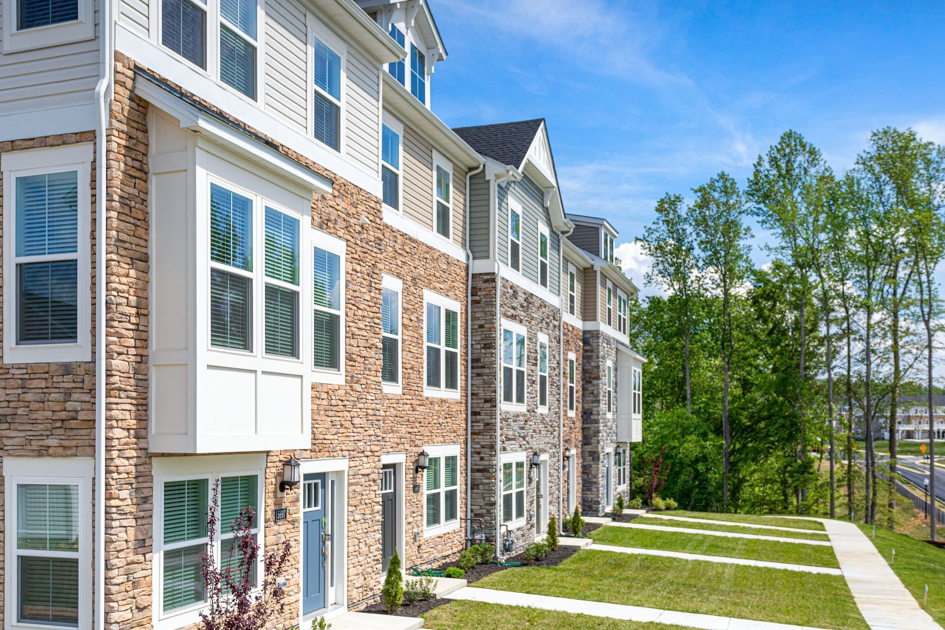 A large apartment building with a lot of windows and trees in the background.