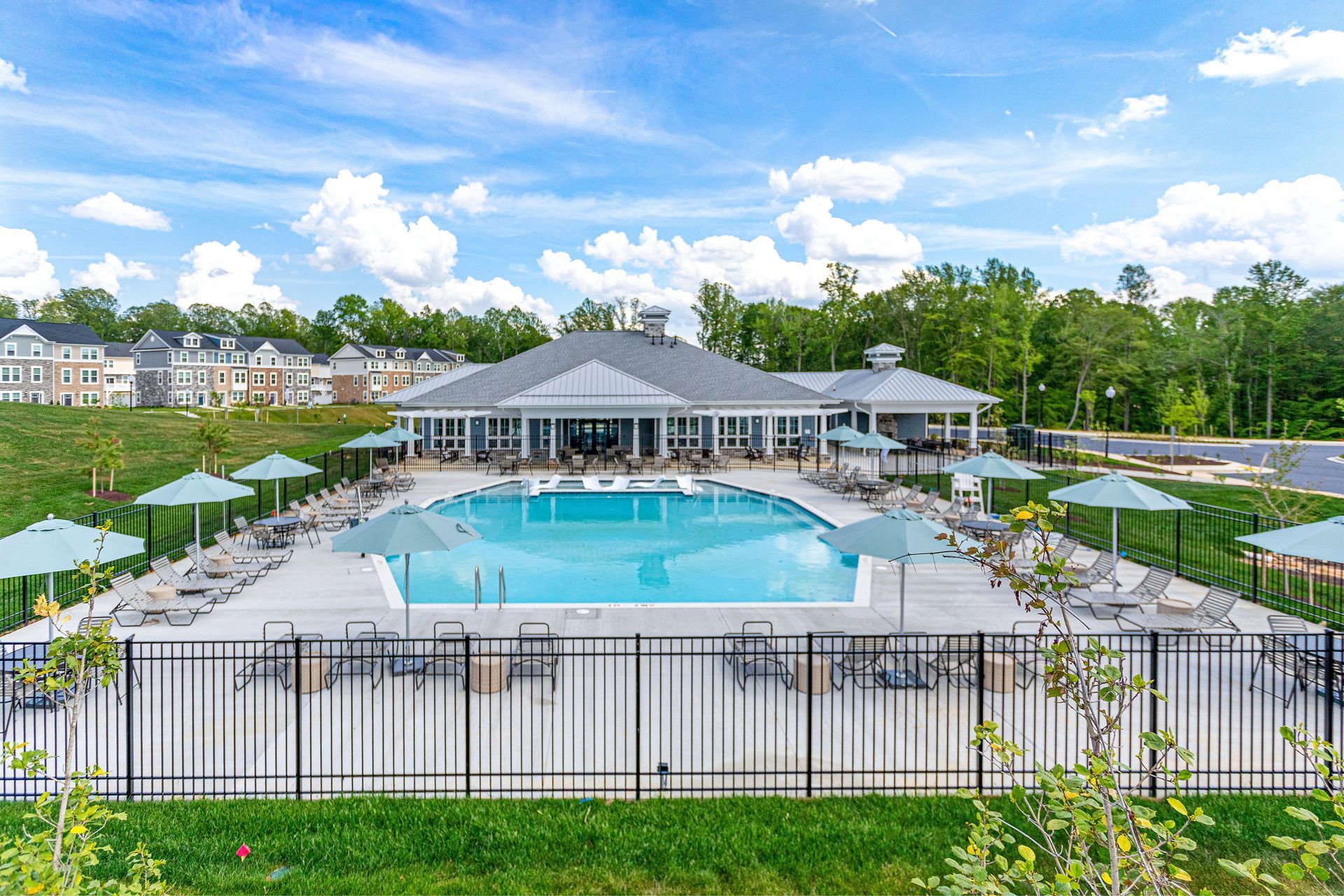 An aerial view of a large swimming pool surrounded by umbrellas and chairs.