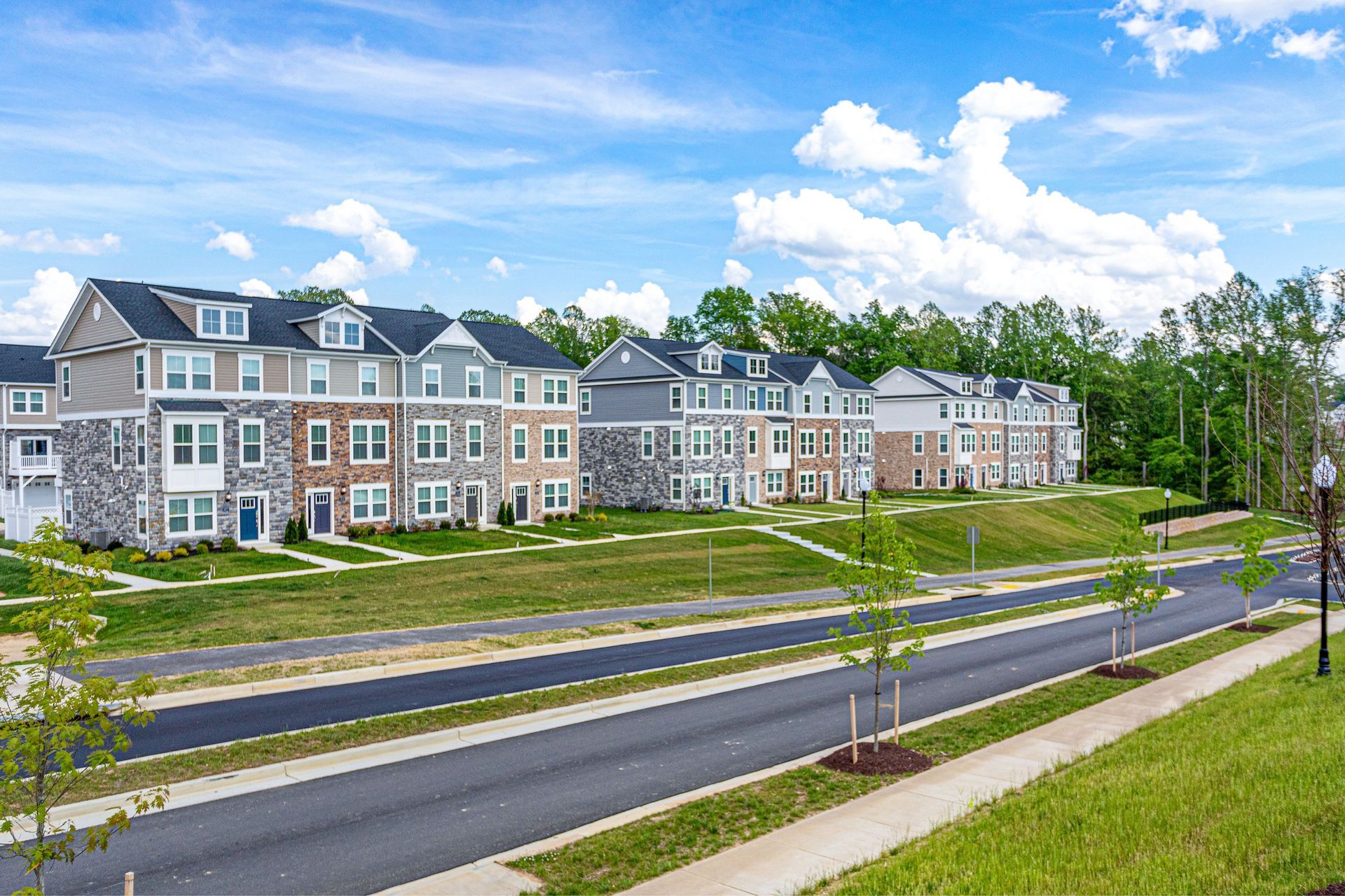 A row of houses sitting next to each other on the side of a road.
