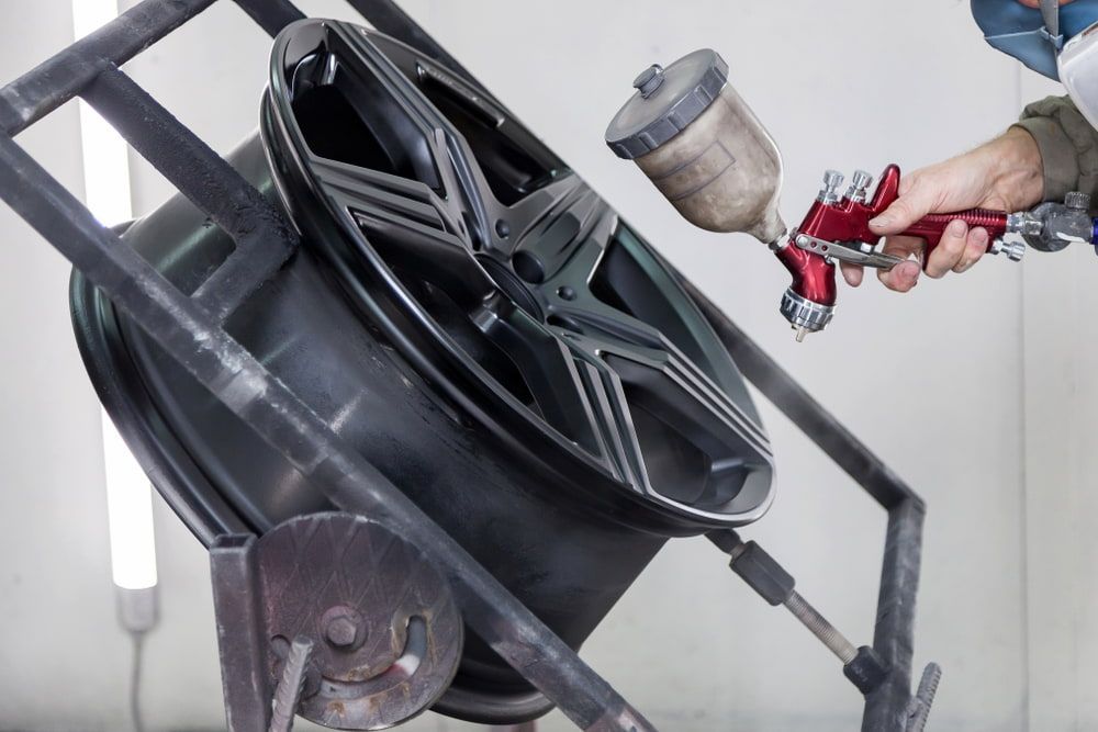 A Man Working and Spray Painting a Car — Seabreeze Auto Body in Coffs Harbour, NSW