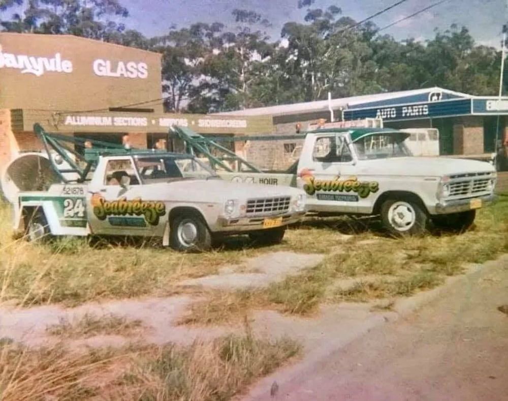 Two Tow Trucks Parked in Front of a Building That Says Glass — Seabreeze Auto Body in Coffs Harbour, NSW