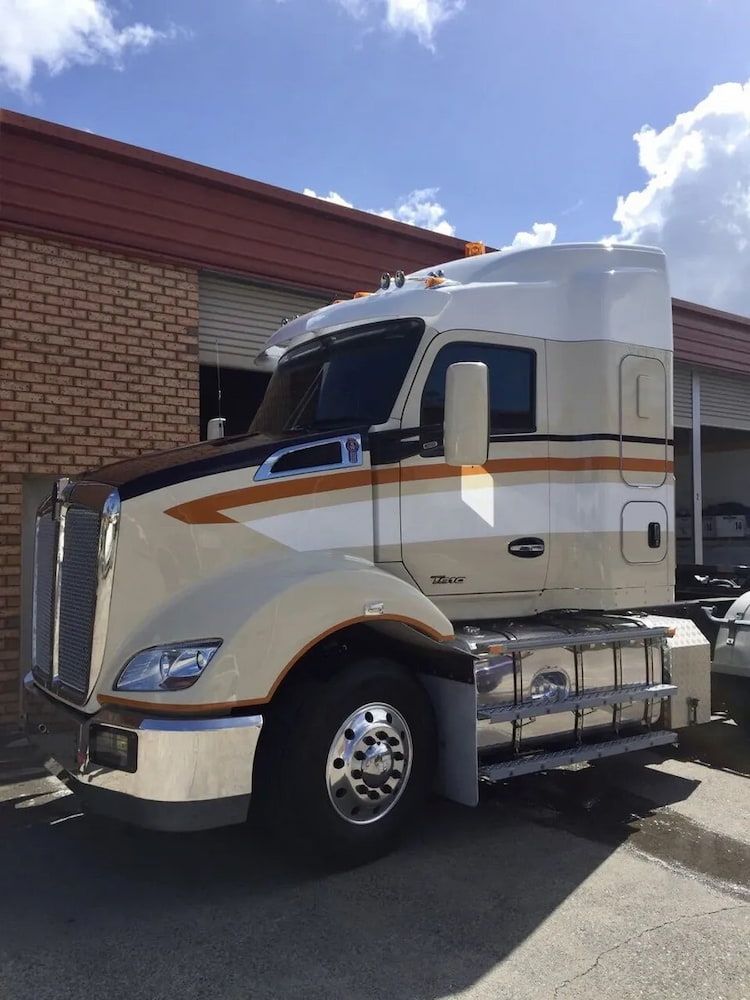 A Semi Truck is Parked in Front of a Brick Building — Seabreeze Auto Body in Coffs Harbour, NSW