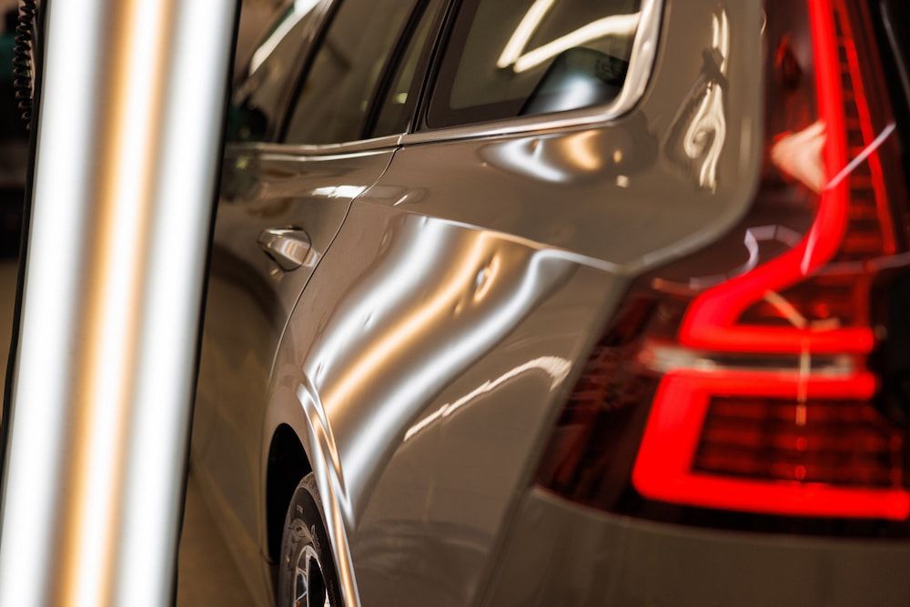 A Silver Car With a Red Tail Light is Parked in a Garage — Seabreeze Auto Body in Coffs Harbour, NSW