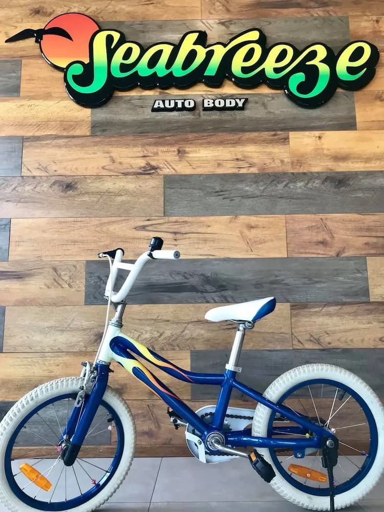 A Blue Bicycle is Parked in Front of a Sign That Says Seabreeze — Seabreeze Auto Body in Coffs Harbour, NSW