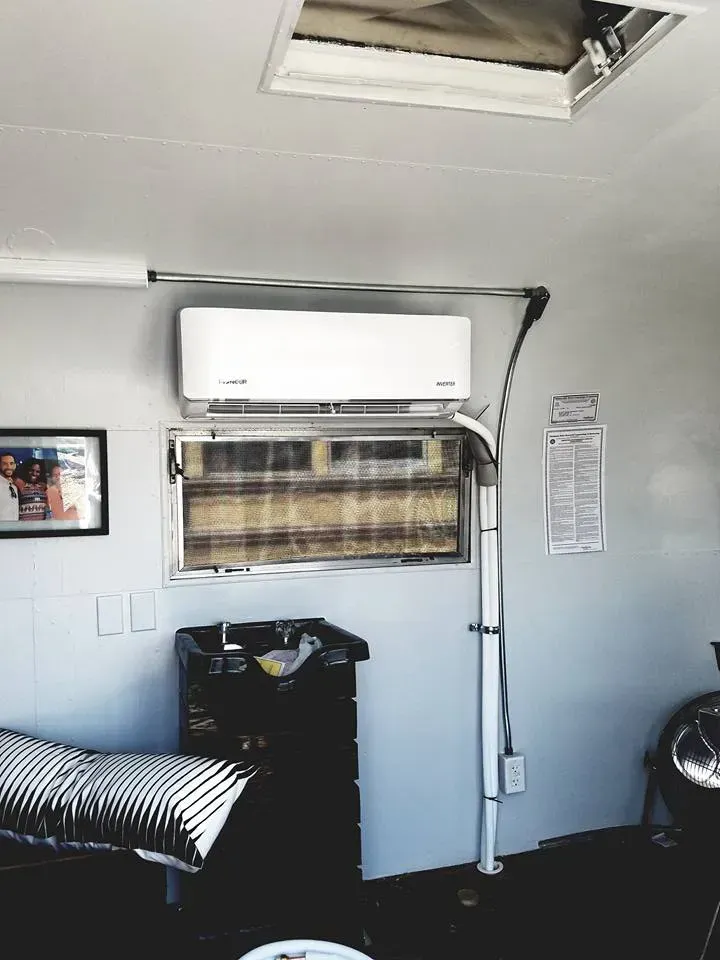 A room with a picture on the wall and an air conditioner