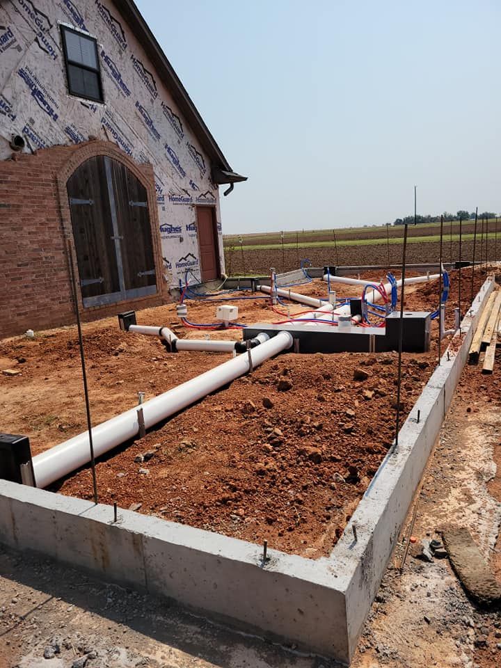 A house is being built with a lot of pipes in front of it