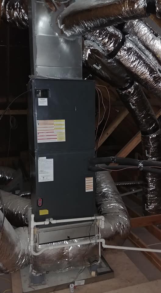 A heating and cooling system is installed in the attic of a house.