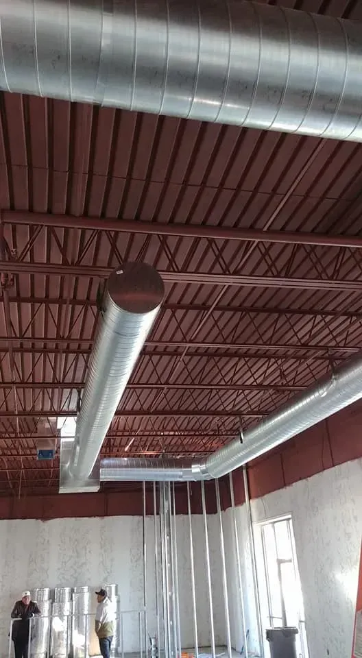 A large room with a ceiling that has a lot of pipes hanging from it.