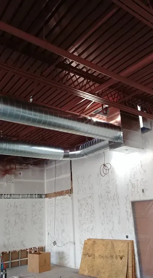 A room with a ceiling that has a lot of pipes hanging from it.
