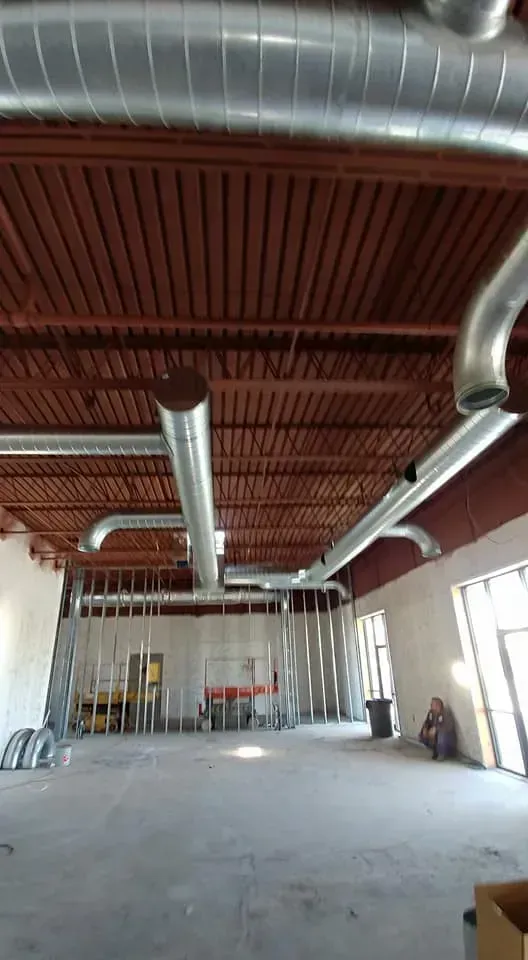 A large room with a lot of pipes hanging from the ceiling.