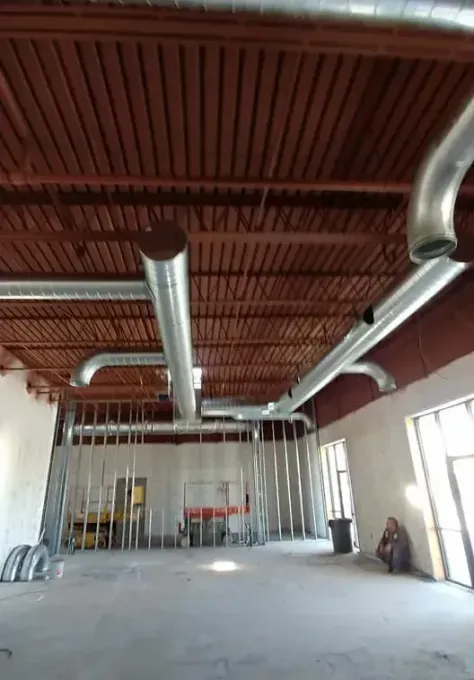 A large room with a lot of pipes coming out of the ceiling.