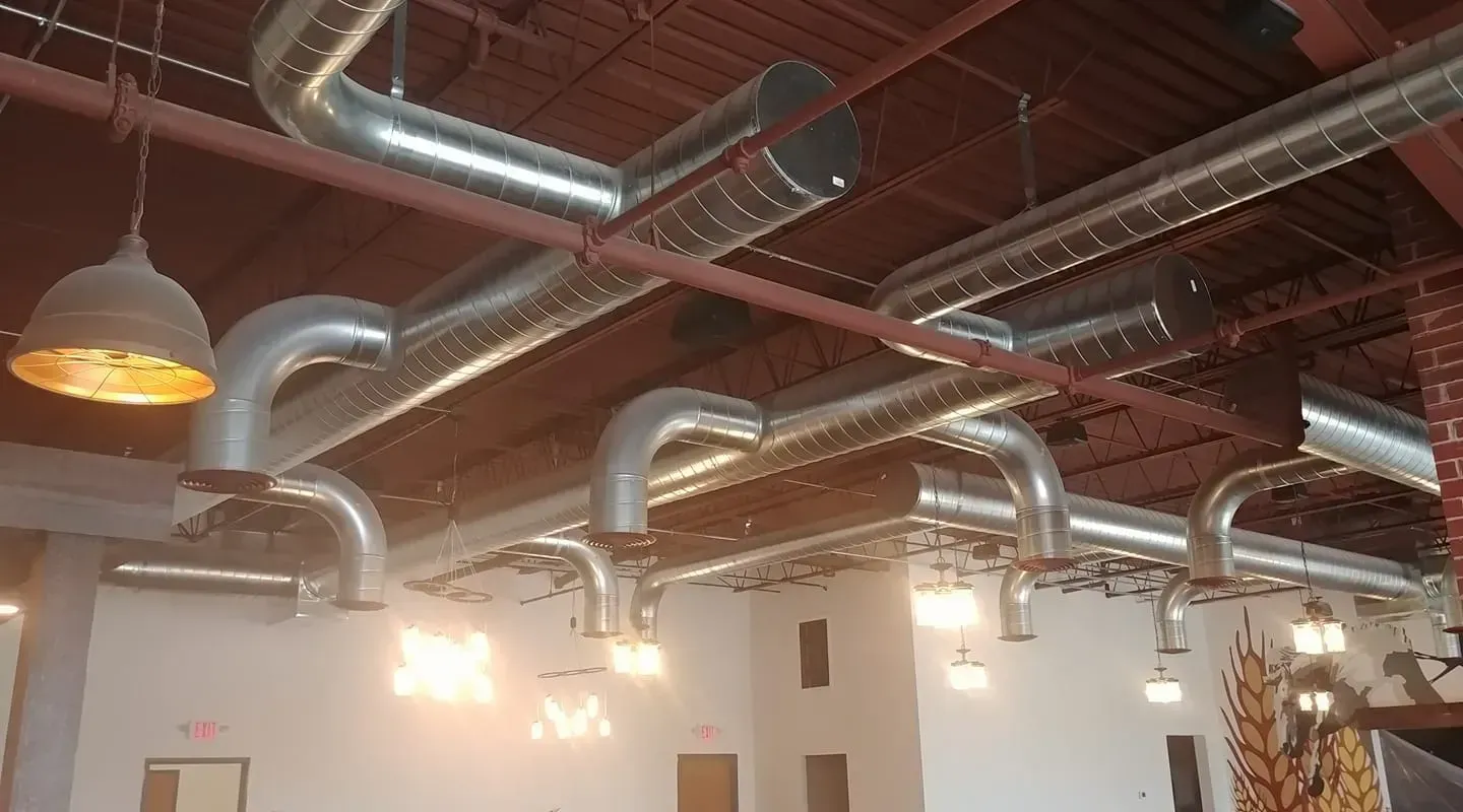 A room with a lot of pipes hanging from the ceiling