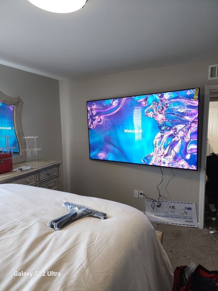 A bedroom with a large flat screen tv mounted to the wall.