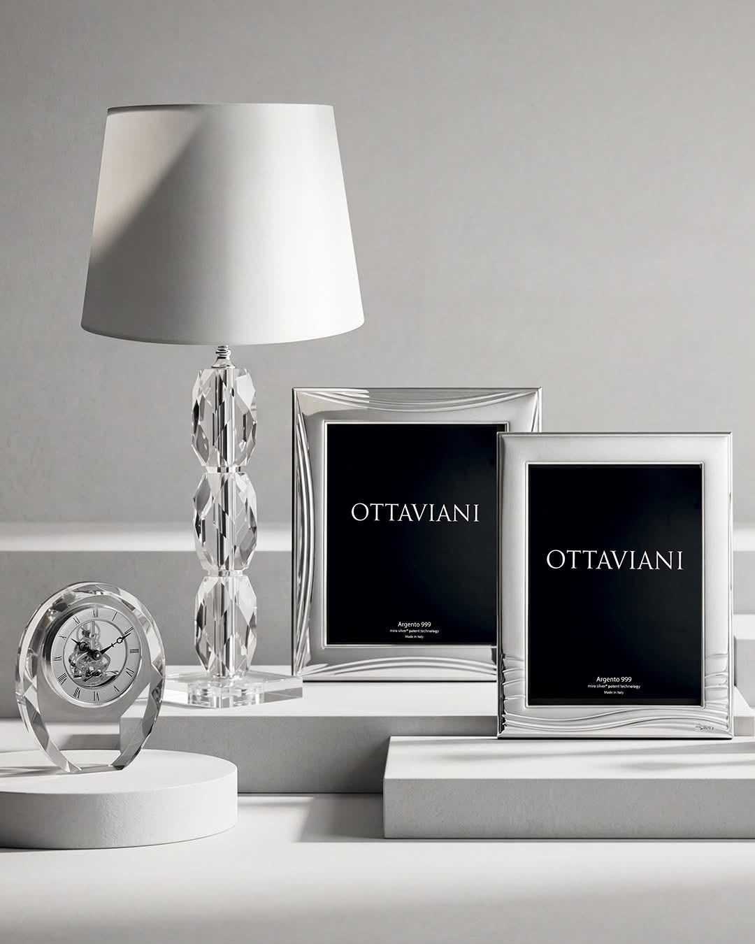Elegante composizione da tavolo con lampada bianca, cornice argentata, orologio e portafoto neri “OTTAVIANI”