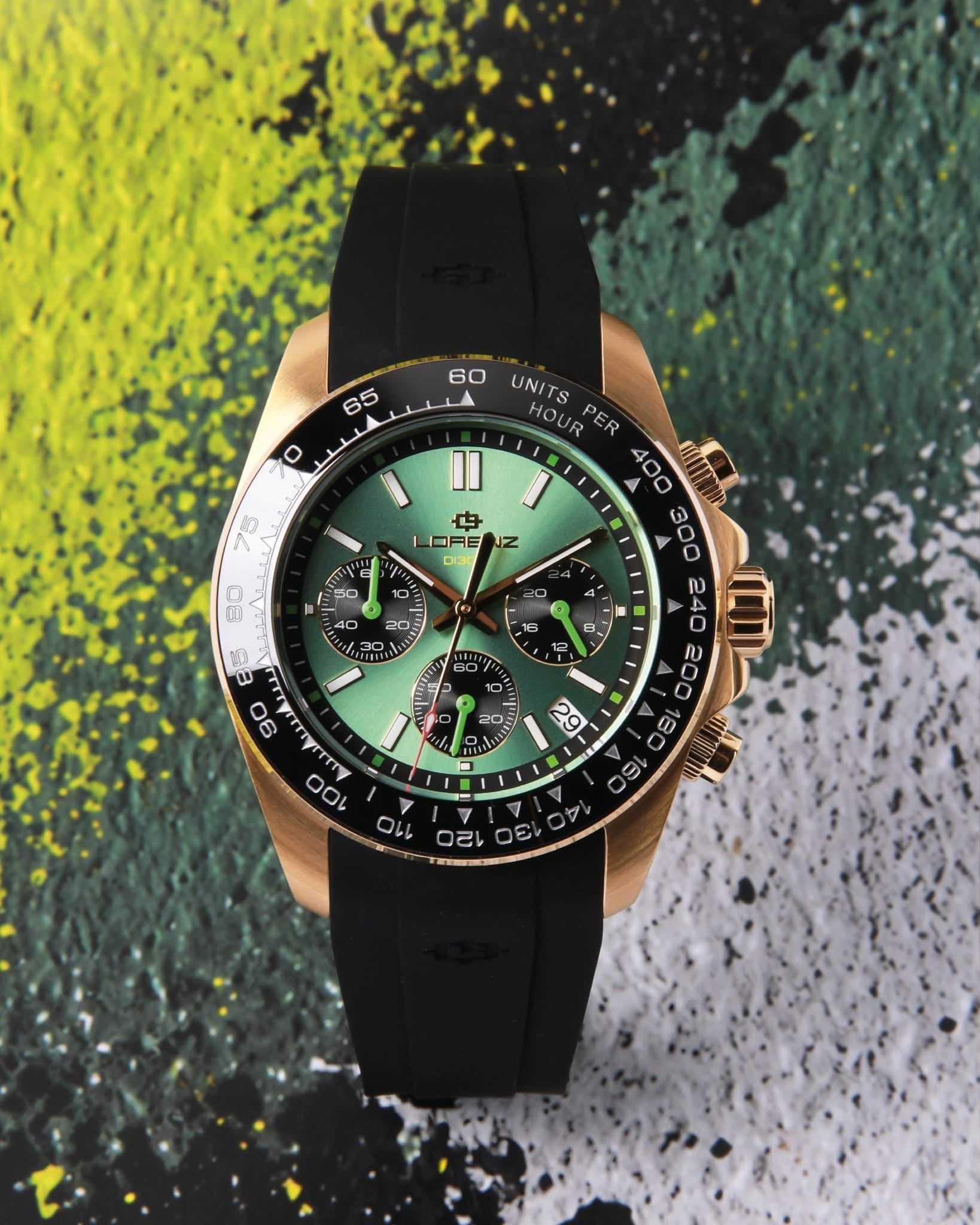 Orologio da polso verde e nero con dettagli dorati su uno sfondo astratto materico