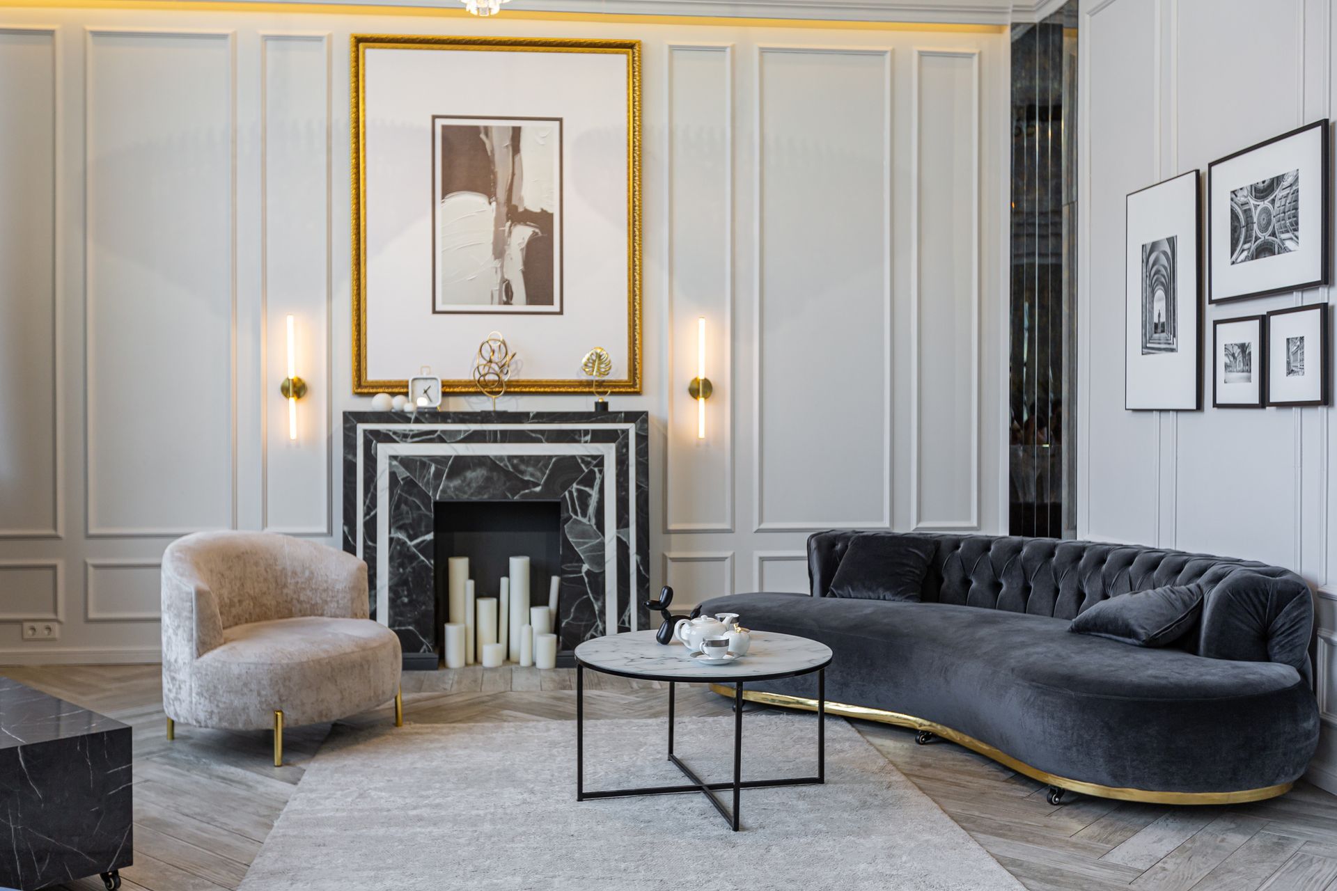 Elegant living room with a gray sofa, marble fireplace, and artwork.