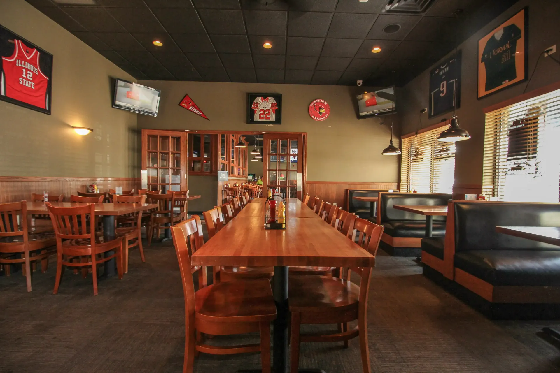 A restaurant with tables and chairs and a long table
