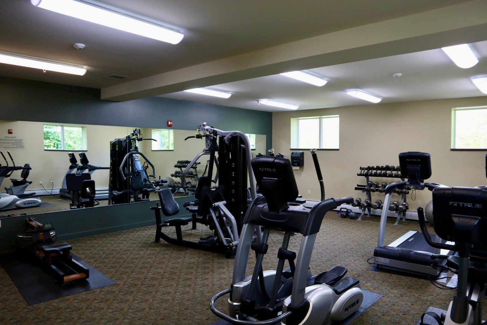A gym with a lot of equipment and a large mirror