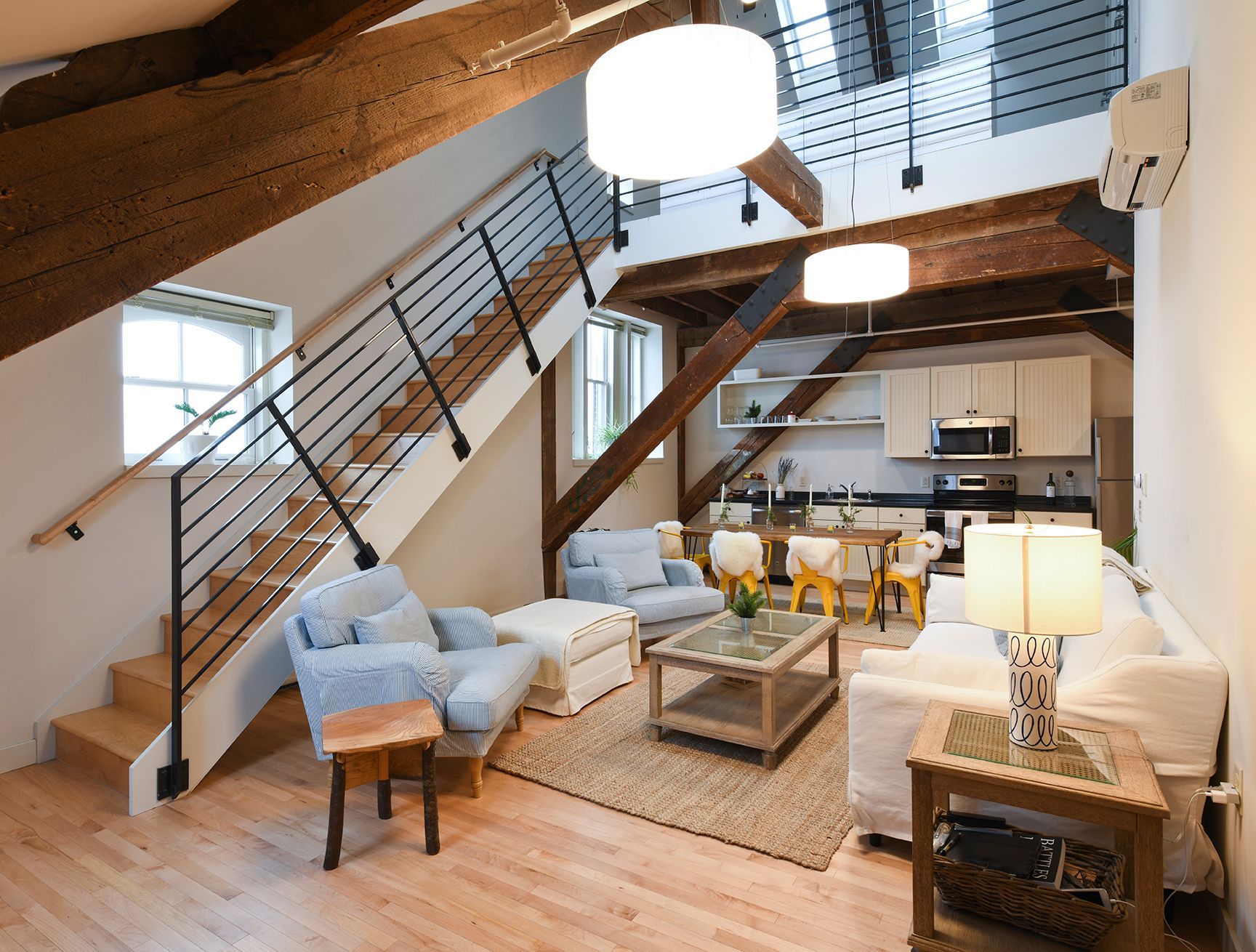 A living room with a staircase leading up to the second floor
