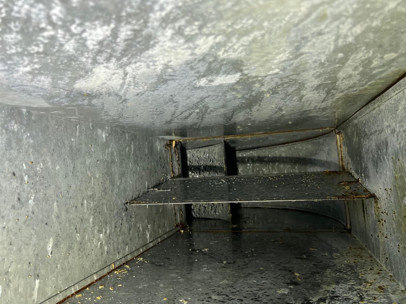 Un conduit d'air sale avec beaucoup de poussière dessus.