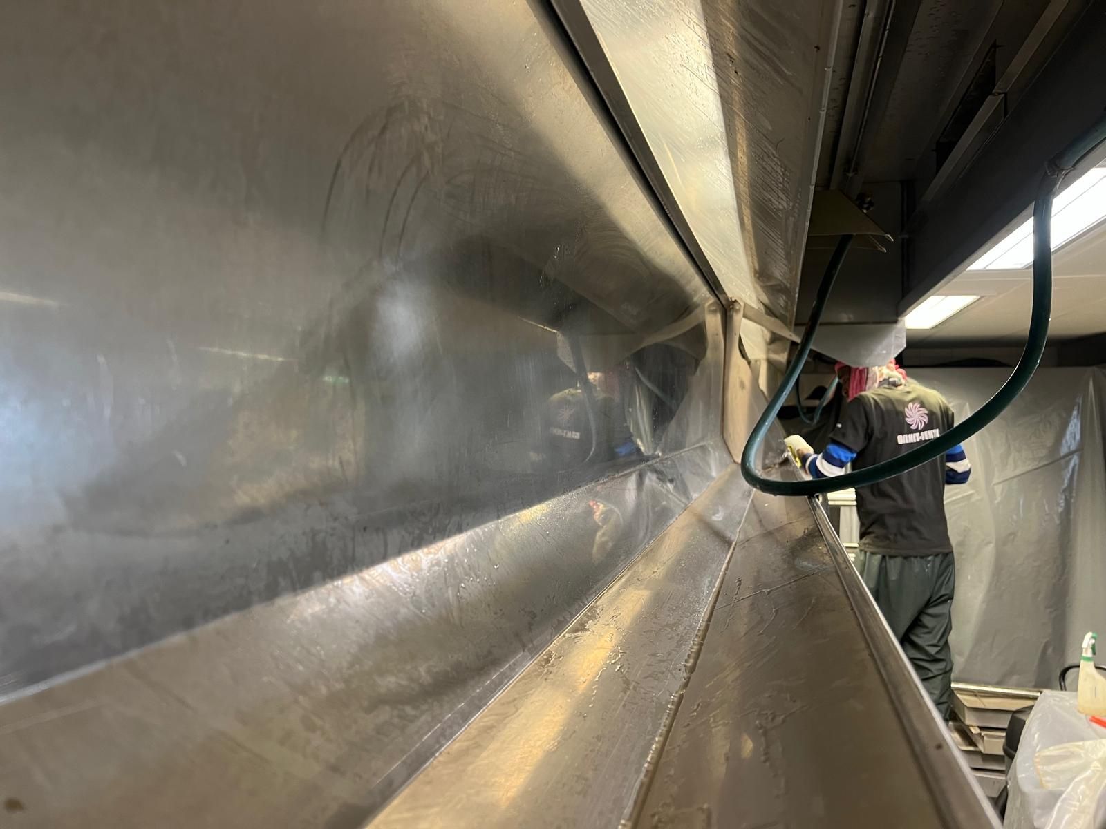 Un homme travaille sur un mur en acier inoxydable.