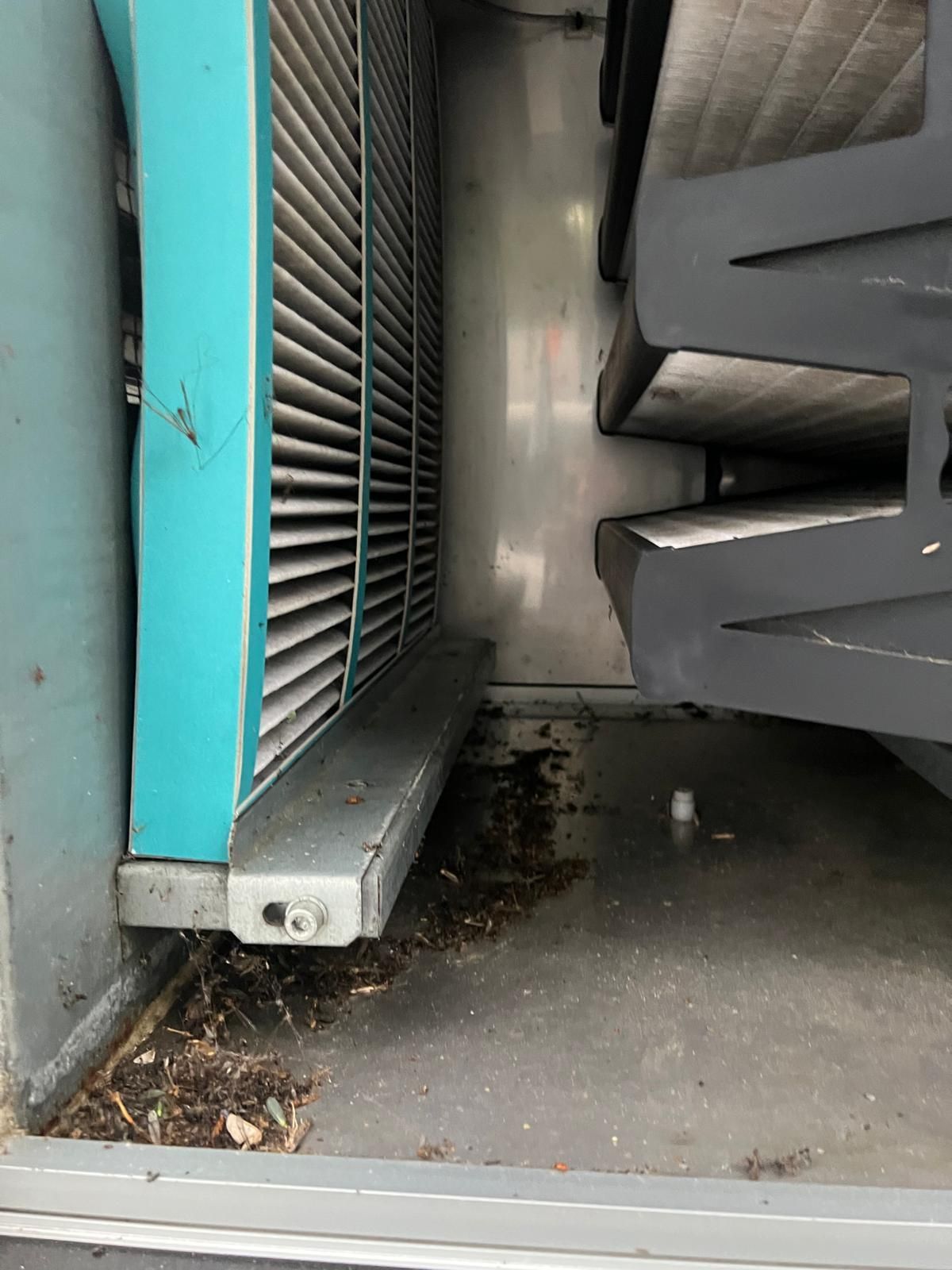 Un climatiseur bleu est posé sur le sol à côté d'un escalier.