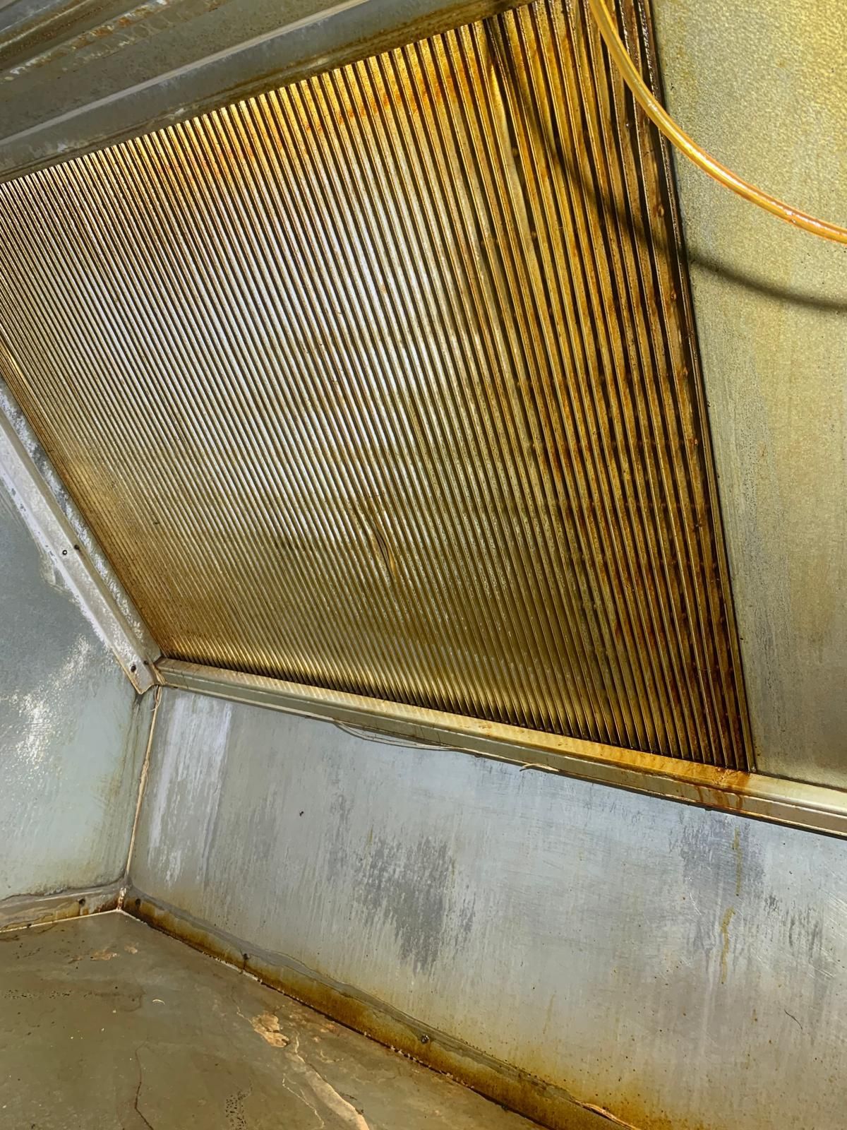 Gros plan d'une hotte d'extraction rouillée dans une cuisine.