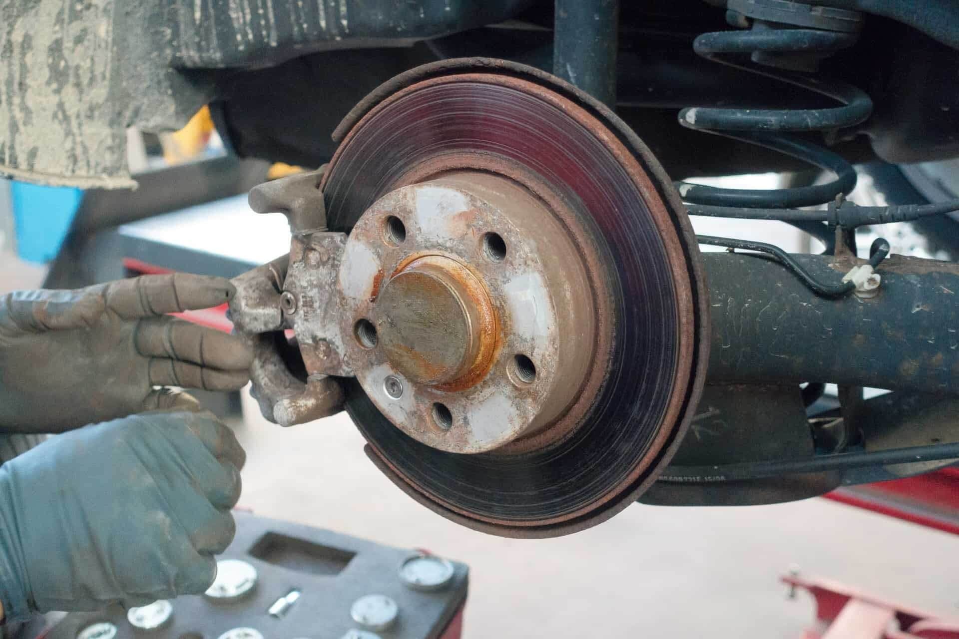 A person is working on the brake pads of a car | Doctor of Motors