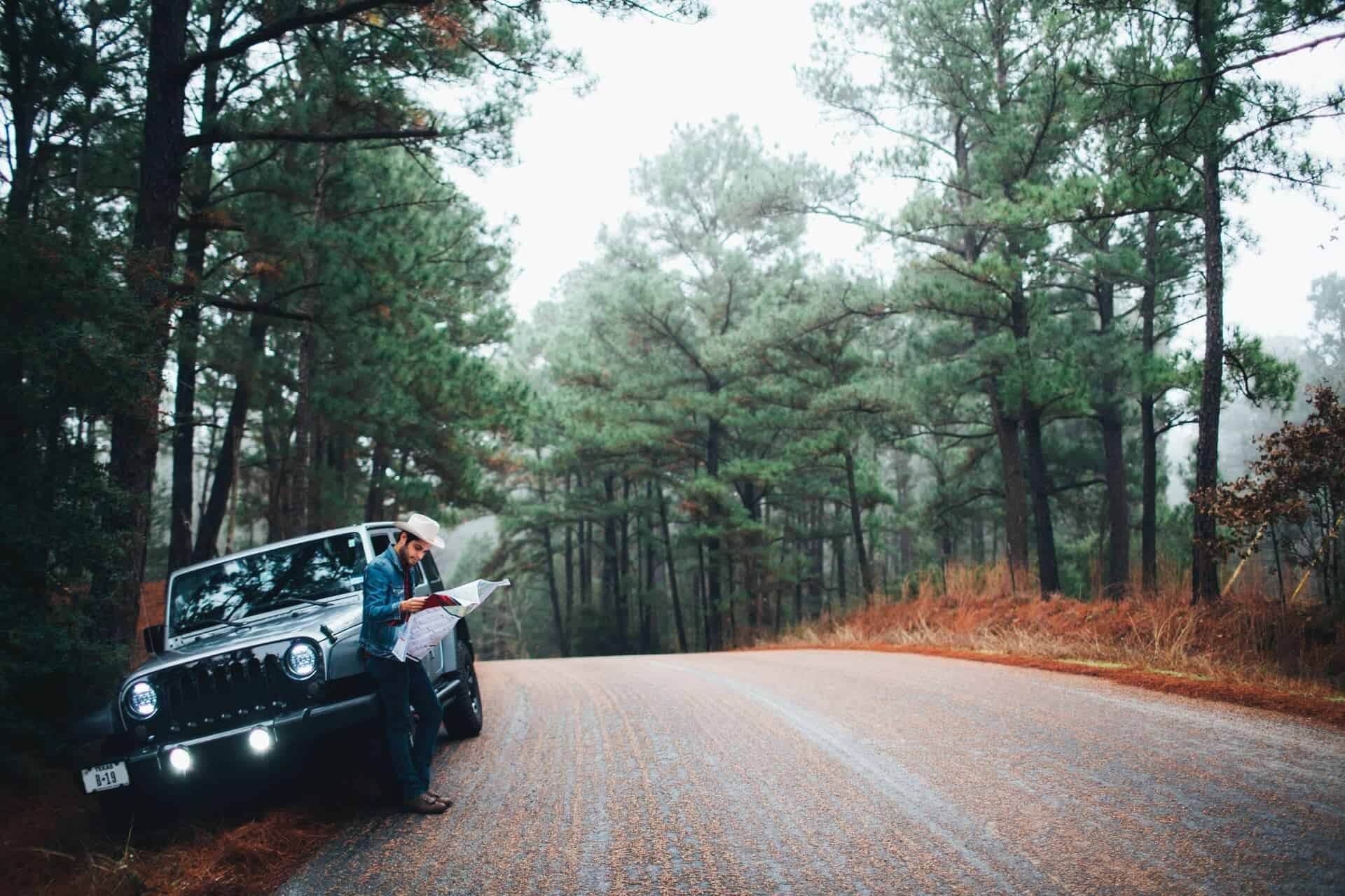 A man is standing next to a jeep on the side of a road | Doctor of Motors