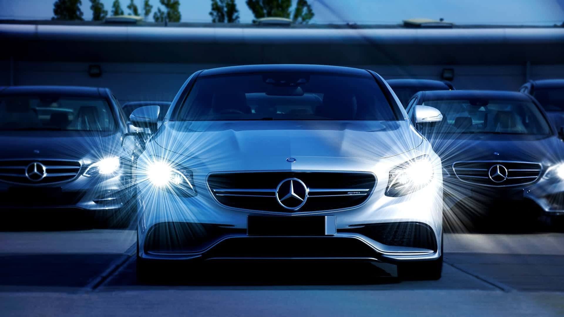 A row of mercedes benz cars are parked in a parking lot | Doctor of Motors