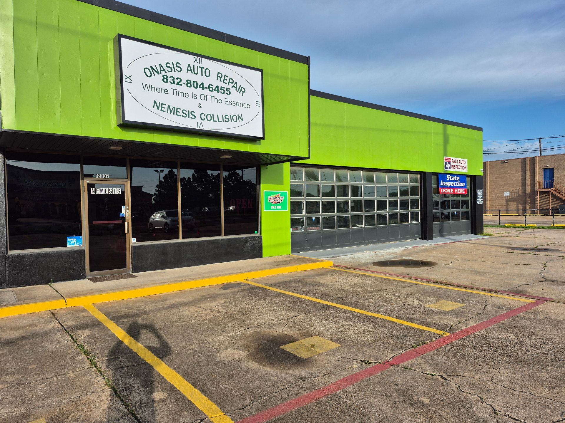 Green storefront with empty parking spaces and a garage-style front door