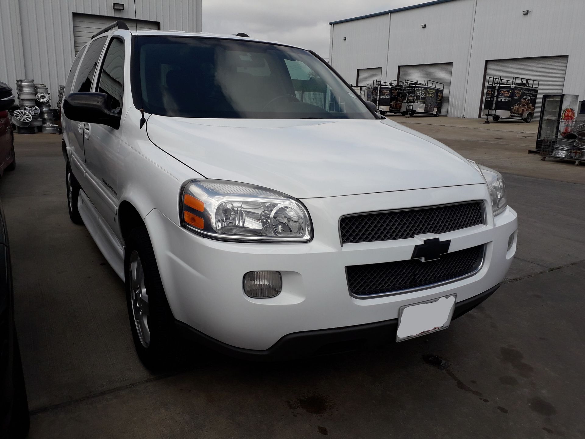 White SUV parked in an industrial lot, front-left view