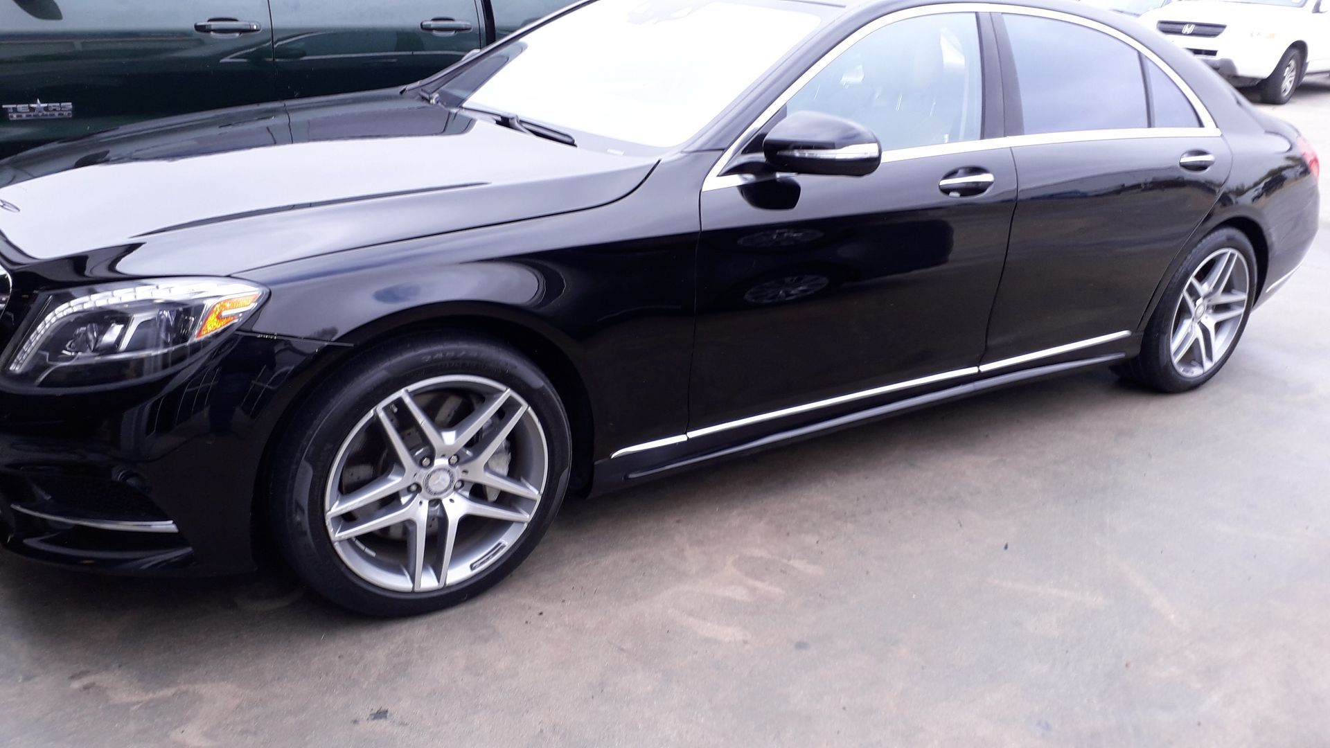 Black Mercedes-Benz sedan parked outdoors on a paved lot