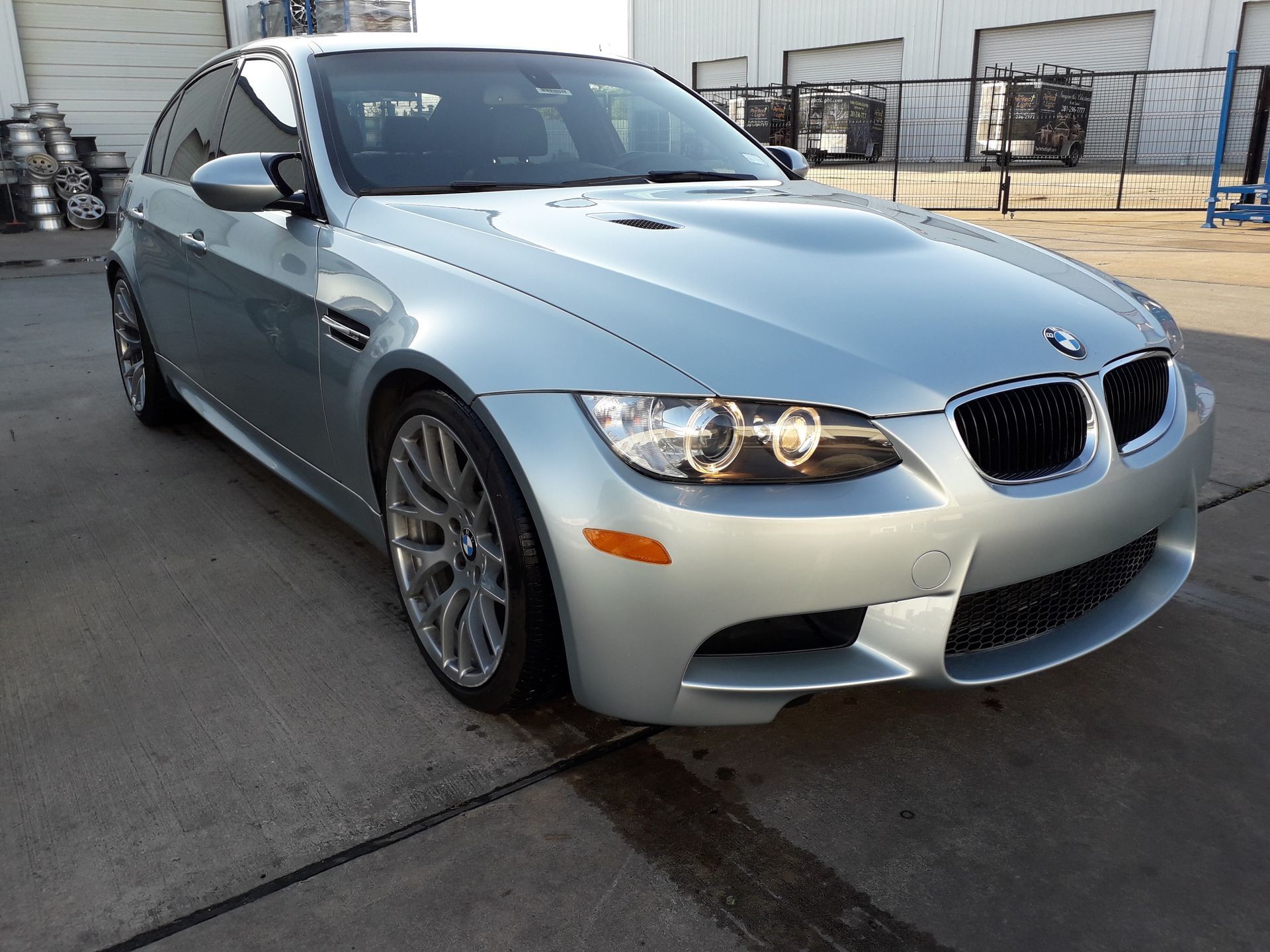 Silver BMW sports sedan parked outdoors on pavement, front-left view.