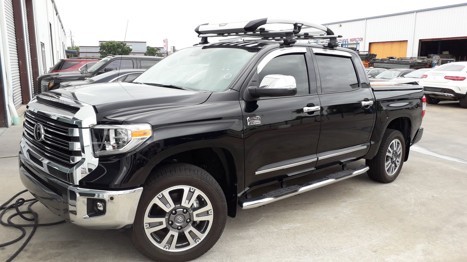 Black pickup truck parked outdoors in a lot, shown from the front-left side.