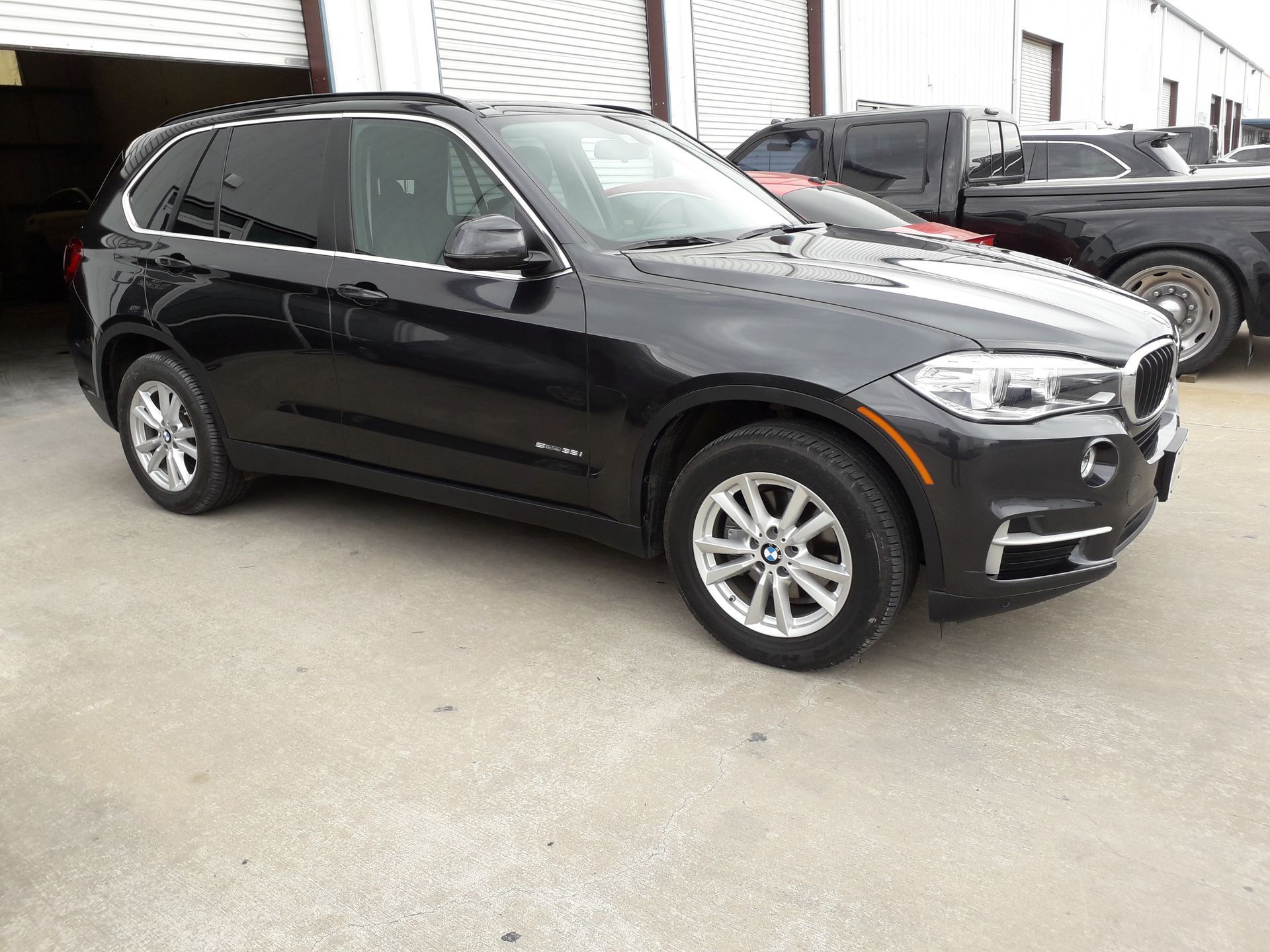 Black BMW SUV parked outdoors beside a building.