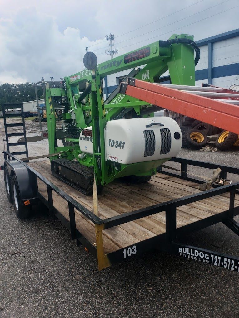 A green and white machine is sitting on top of a trailer.