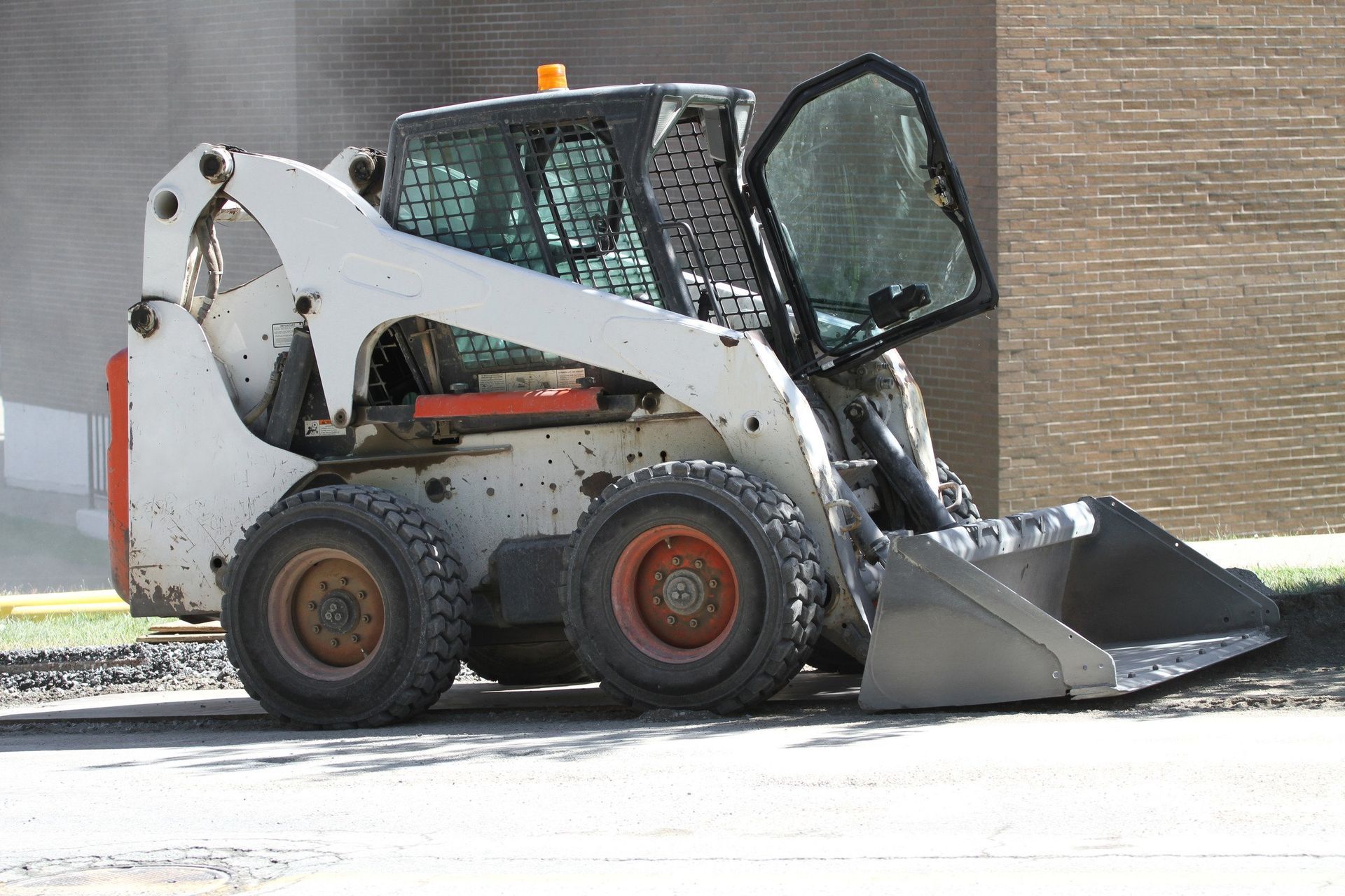 A bobcat skid steer is parked on the side of the road.