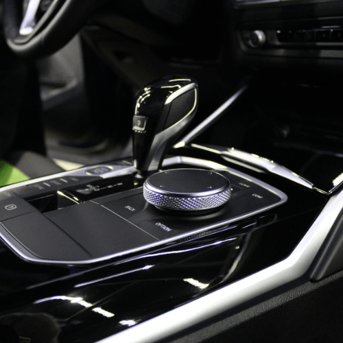 Luxury car center console with gear selector and rotary control knob in black and silver