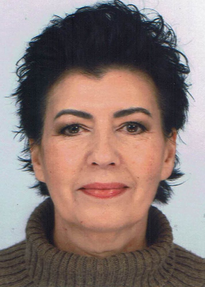 Een close-up van het gezicht van een vrouw die een bruine trui draagt.
