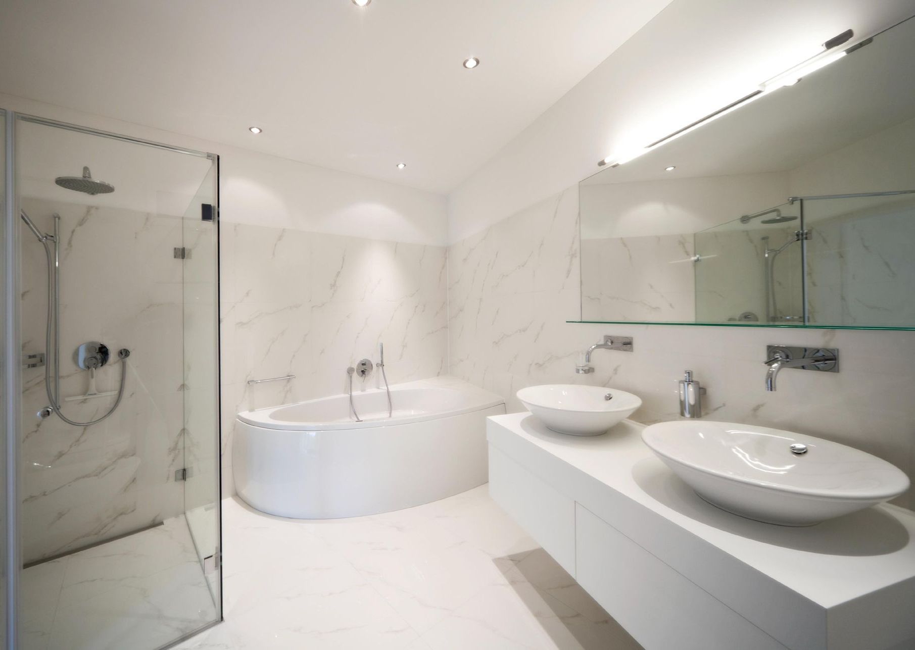 A bathroom with a walk in shower with a glass door.