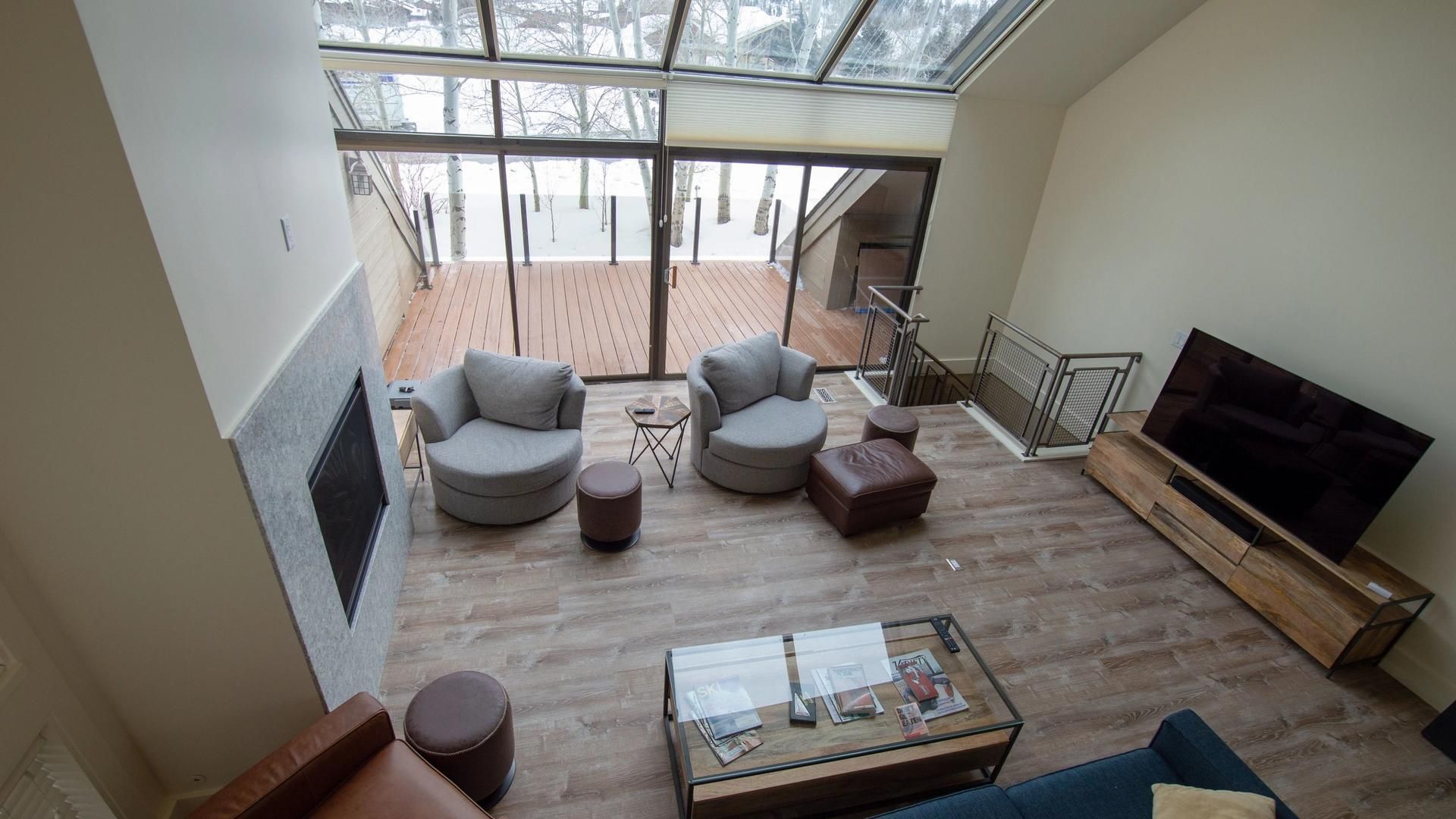 An aerial view of a living room with a couch , chairs , coffee table and television.