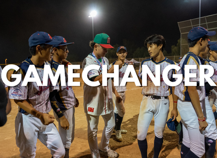 Baseball players in blue and white uniforms walking on a lit field with “GAMECHANGER” text overlaid